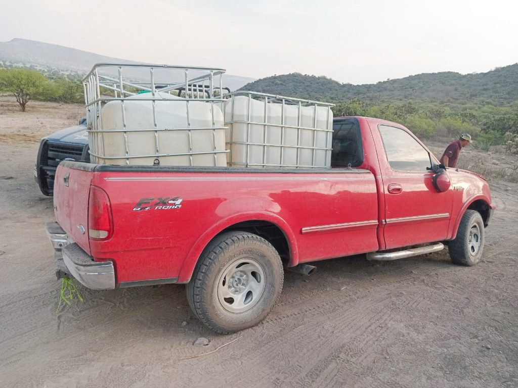 Camioneta roja cargada con tanques de combustible robado.